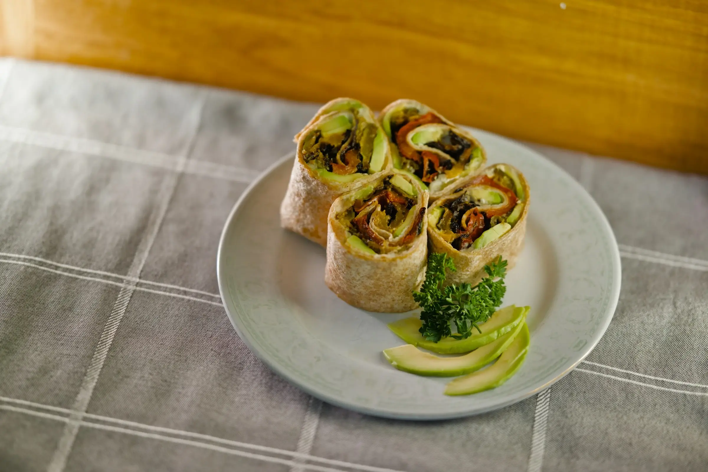 Roasted vegetable and houmous wrap cut in half.